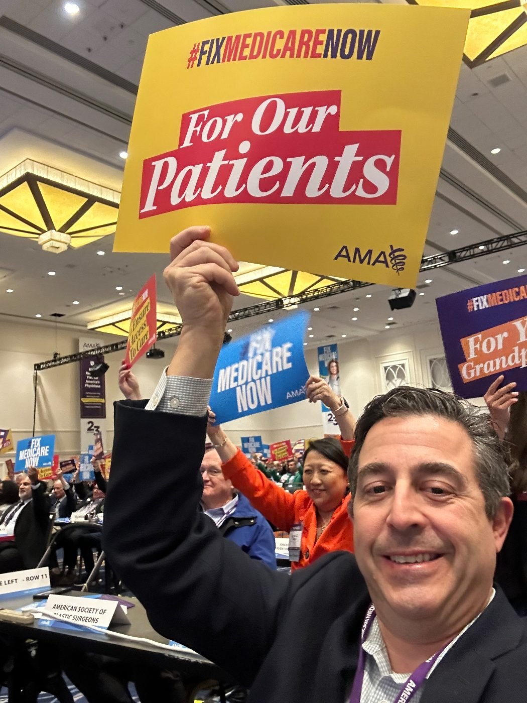 Dr. Scott at the AMA House of Delegates holding a #FixMedicareNow 'For Our Patients' sign