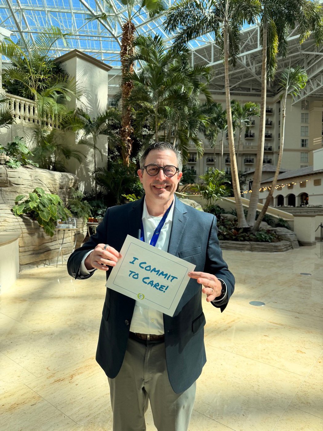 Dr. Scott holding an 'I Commit to Care' pledge at the ASMBS Obesity Summit